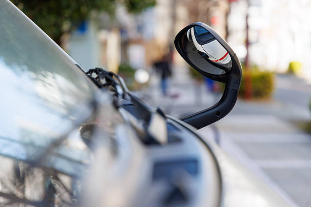 Shanghai, China - February 12, 2013: A green city bus travels down a Shanghai road while a Chinese woman's reflection can be seen in a road safety mirror. Tangles electrical wires on an electricity pole are also visible in the photo.