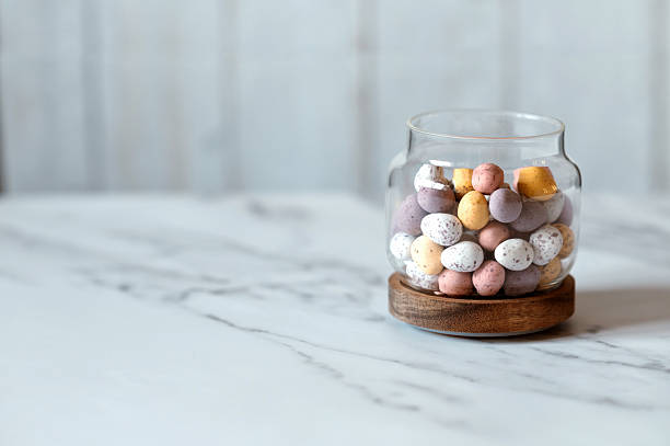 Easter chocolate Multi-Colored eggs in pastel colors in glass jar. High quality photo