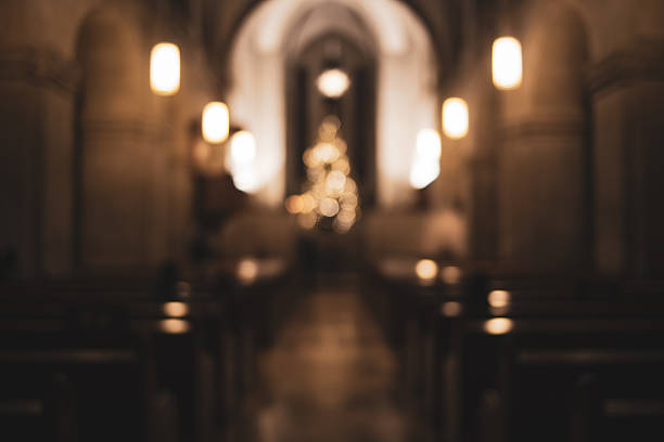 Blurred, dark and moody church interior abstract background. Wide angle view, artificial lights in the background