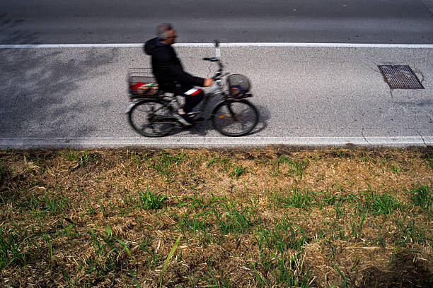 Pellestrina, Italy - April 27, 2025: Photo of a cyclist in the street creating a panning effectt