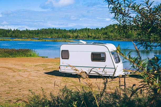 Scenic Lakeside Setting Featuring a Cozy Caravan Amidst Nature's Calm Serenity.