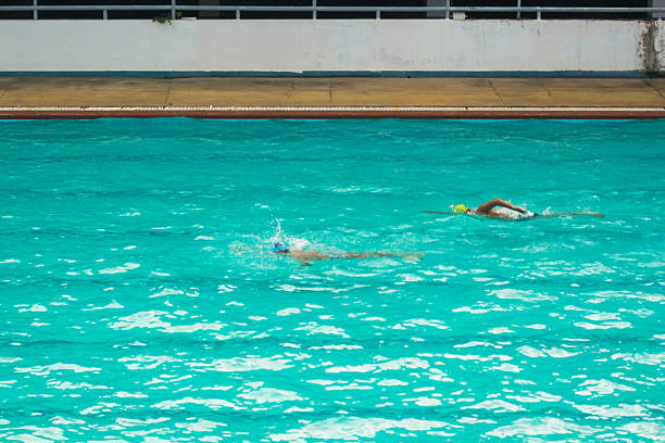 Instructor talking with a competitive para athlete swimmer with double arm and leg amputations at swimming pool