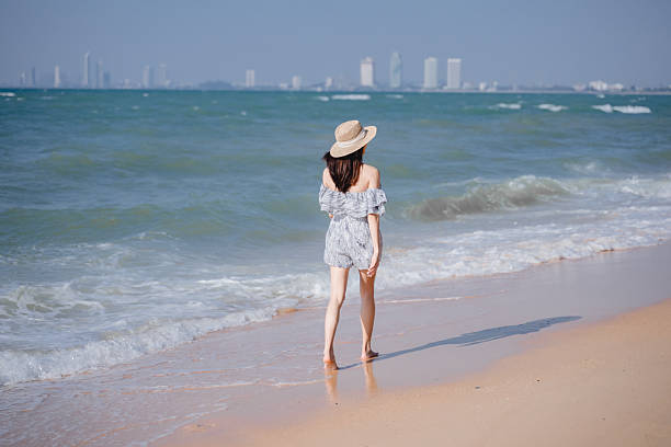 Beautiful woman wears a straw hat with a natural texture that provides shade while adding a summery stylish the straw hat create playful enhancing the cheerful and relaxed mood of the photograph.