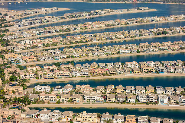 Palm Jumeirah aerial view of luxury waterfront villas lining the iconic man-made island fronds, blue lagoons and coastline in sunny Dubai, ideal for real estate and travel
