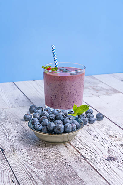Heirloom blueberries and a blueberry and coconut milk smoothie on a light ash table
