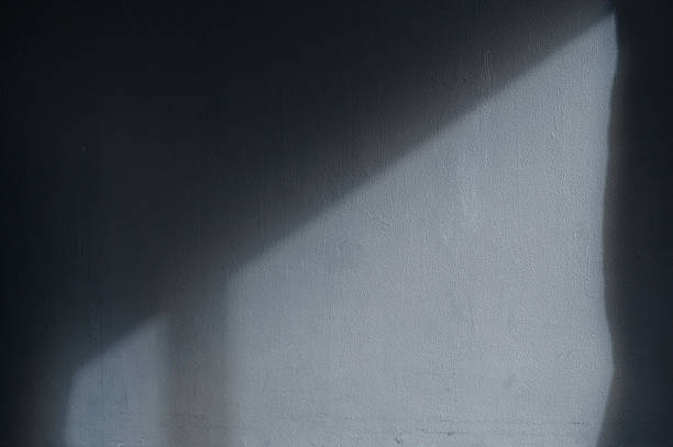A gray wall illuminated by sunlight coming in through the window
