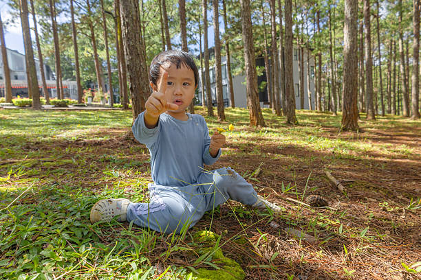 The baby is crying while playing and falling in the garden, connecting with nature, exploring the world. Photo stock
