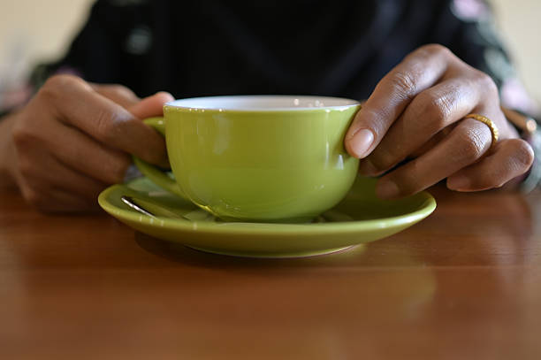 Hands holding ceramic cup of tea