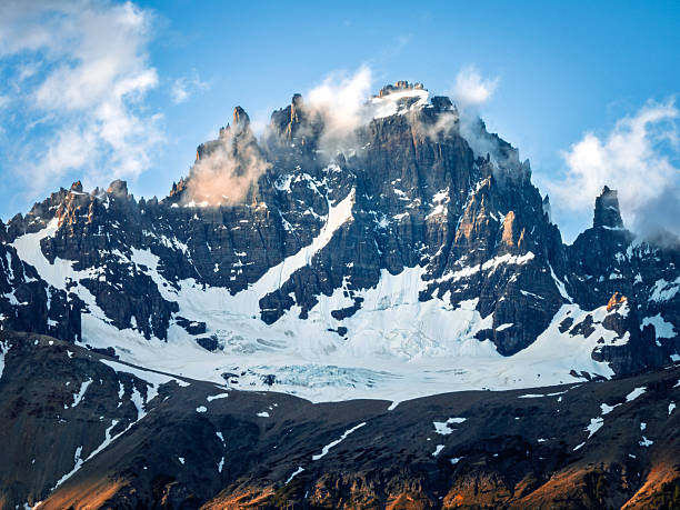 Striking view of the Cerro Castillo massif showing snowfields, dark rock faces, and steep ridges. The image conveys power, elevation, and the raw geology of Patagonia.