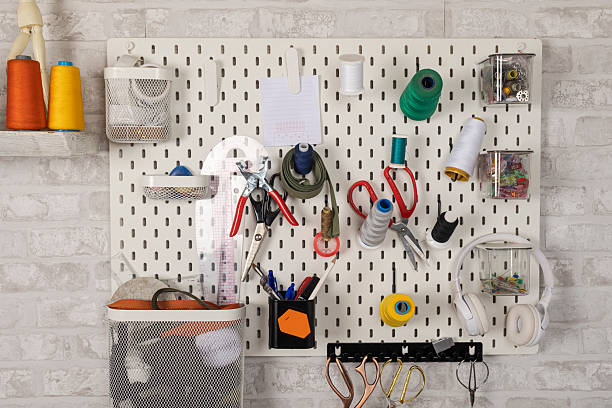 Pegboard storage system keeping sewing accessories and craft supplies organized on a brick wall