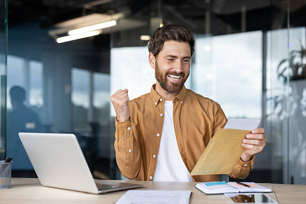istock Happy man celebrating good news reading letter 2256080221