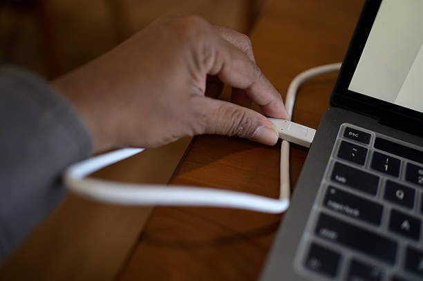 A USB cable is resting on a fabric surface with a pattern. The scene shows part of the cable and the surrounding area in a well-lit room during the day.