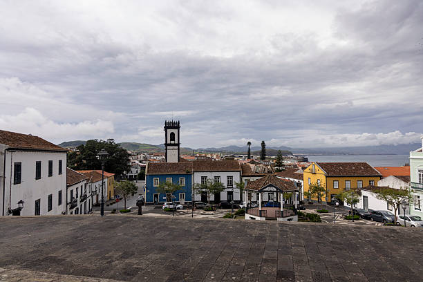Ribeira Grande, Azores, Portugal, October 8, 2025: A town with a church and a blue house. The sky is cloudy. The houses are colorful