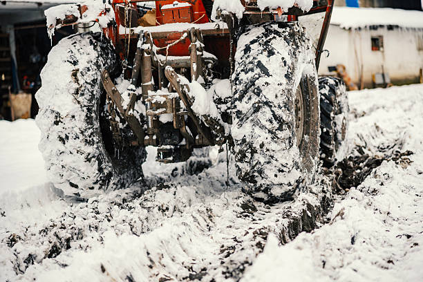 A tractor in a field and snowy landscape