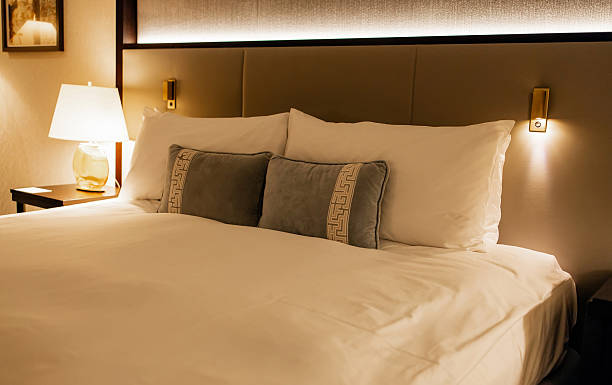 istock Cozy luxury hotel bed with elegant decorative pillows and ambient lighting in a modern interior bedroom 2256094225