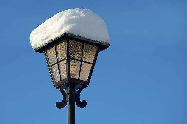 Vintage street light lamp with snow and blue background