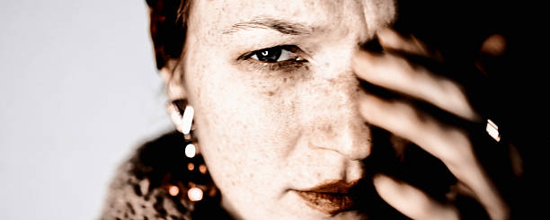 Intimate portrait of a well-known woman caught in harsh frontal light, balancing public exposure, discomfort and the instinct to regain control.
