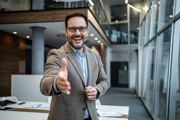 istock Smiling businessman offering hand for handshake in modern office 2256097648