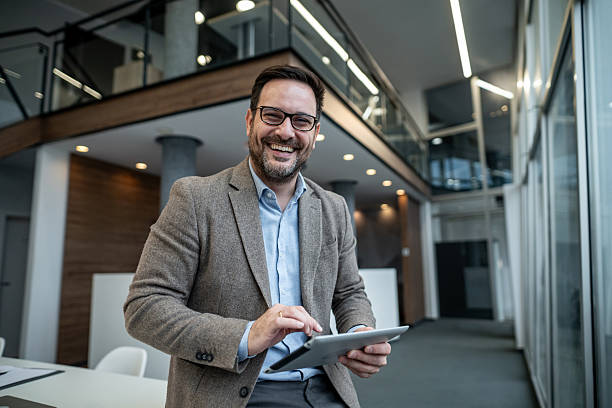 istock Mature adult businessman smiling using digital tablet in modern office 2256097709