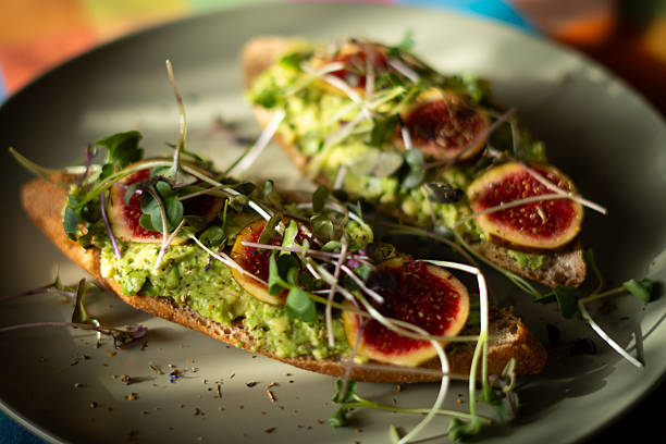 avocado toast with microgreens and figs, sprinkled with chili and cornflower petals