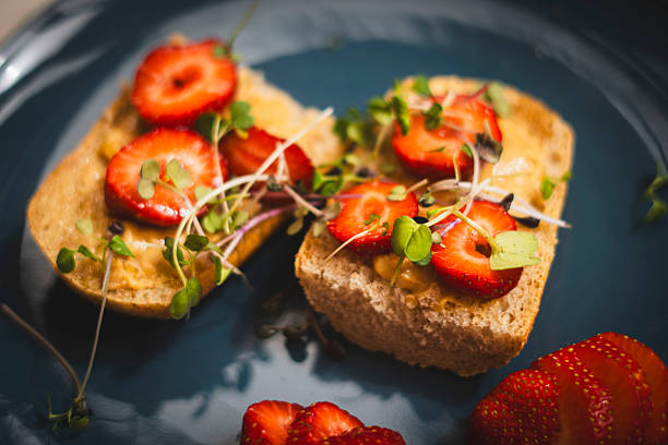 whole grain roll with crunchy peanut butter, strawberries, maple syrup and micro greens