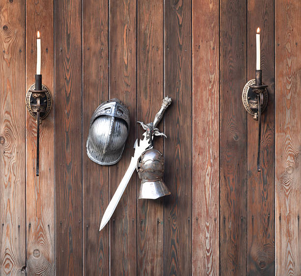 knightly equipment, sword and helmet on wooden background