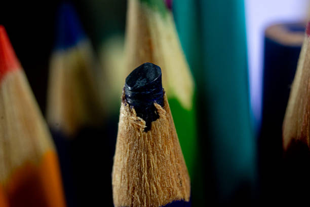 A Vibrant Array of Colored Pencils Creating Artistic Magic on Paper. A group of colored pencils sitting on top of a piece of paper
