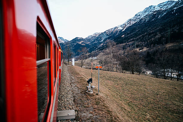 Red Swiss train in a green forest in the European Alps