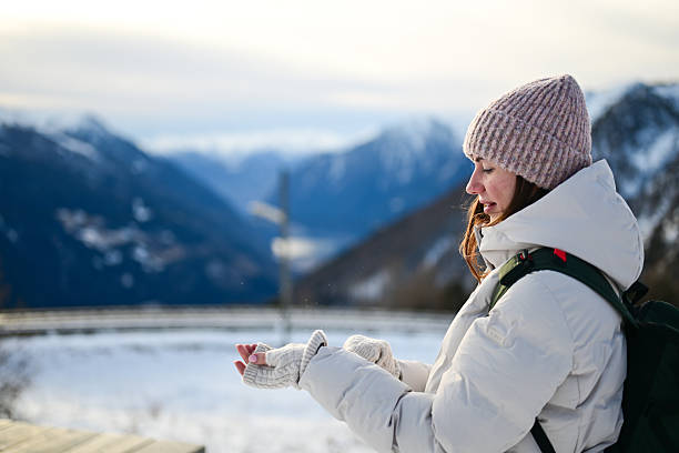 Woman hiking in Alps mountains feeling cold snow