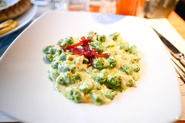 Green gnocchi with creamy sauce and prosciutto speck