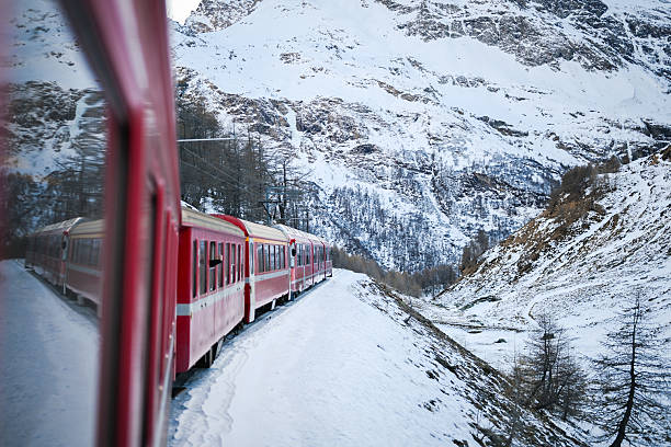 Red train moving in beautiful summer forest in Switzerland