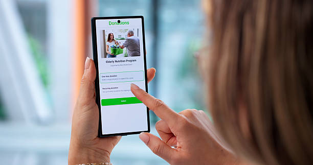 istock Young Woman Using Mobile Phone App To Donate 2256113360