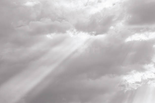 Dramatic sunbeams pierce through a cloudy sky, creating a powerful visual metaphor for hope and spiritual awakening