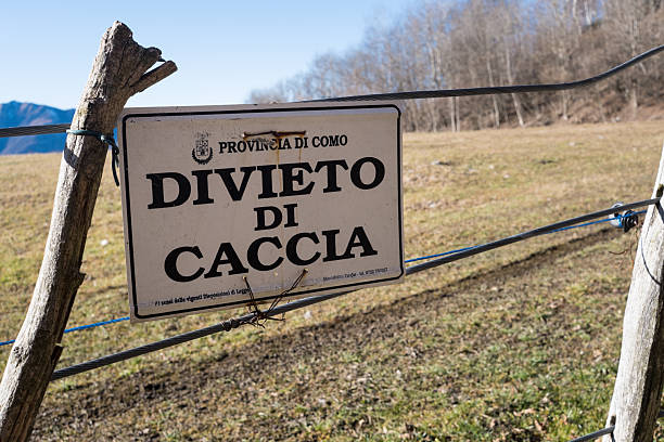 Pian del Tivano, Italy - 2025, December 28 : A no hunting sign written in italian with the words Divieto di Caccia meaning prohibition of hunting, Como Province, Italy