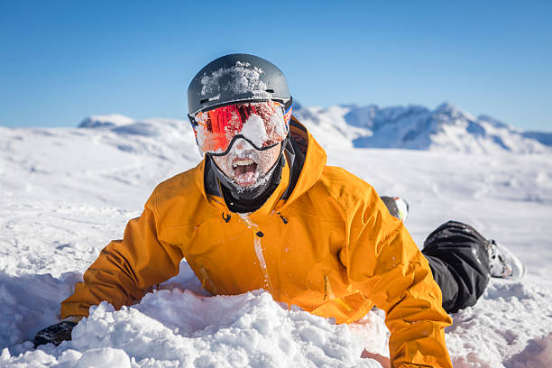 Male snowboarder plays in snow at ski resort on a sunny day in winter, Whistler, British Columbia