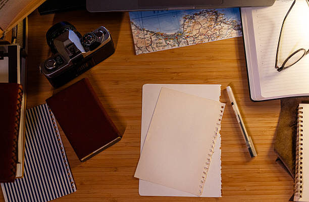 High angle view of a creative workspace with laptop, vintage camera, and map.