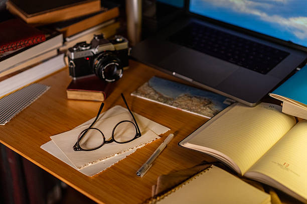 Creative workspace with analog camera, notebook and laptop on wooden desk