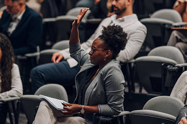istock Woman raising hand asking question at conference 2256124951
