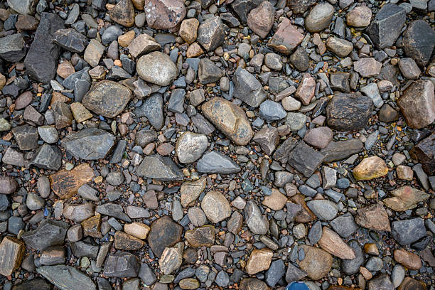 A detailed overhead shot of multicolored rocks and jagged stones found on the shore of a Scottish loch, featuring earth tones and grey slate.