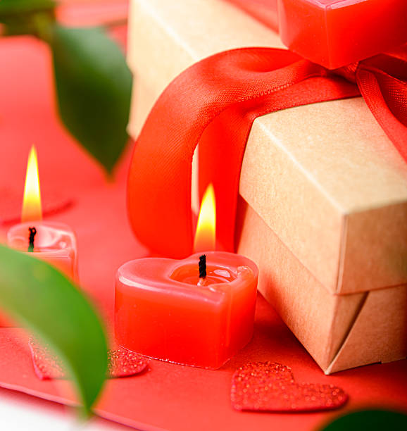 istock Valentines Day romantic gift with red rose, heart shaped candles and wrapped present on red background, love and celebration concept. 2256143375