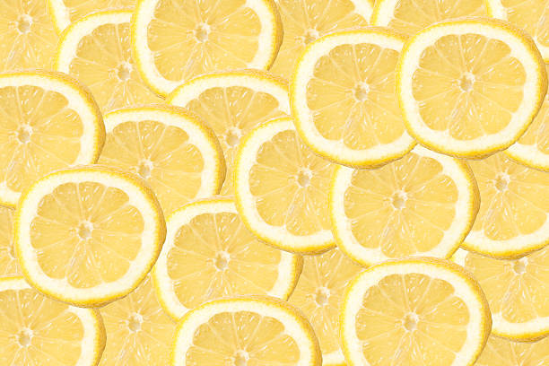 istock Fresh lemon slices pattern background. Yellow citrus fruit rings layered in flat lay composition. 2256144679