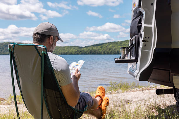 Man Relaxing Close to a Lake With Camper van During Summer