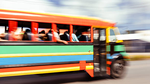 Colorful bus carrying passengers moving quickly on a street in curacao