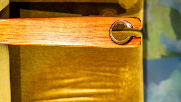 Close-up view of a vintage-style wooden armrest featuring a circular metal cup holder