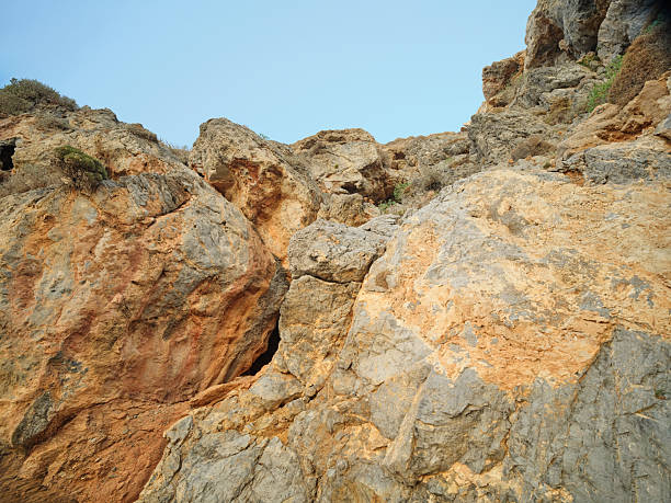 Crete, Greece coastal path along rugged cliffs at sunset. A serene Mediterranean landscape with rocky terrain, low vegetation, and a calm sea to the left. Perfect for travel, nature, hiking, and scenic imagery celebrating coastal beauty and peaceful sunset moments in Greece.