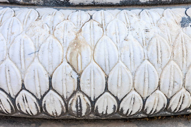 Ancient marble carving detail with leaf pattern on historical column.