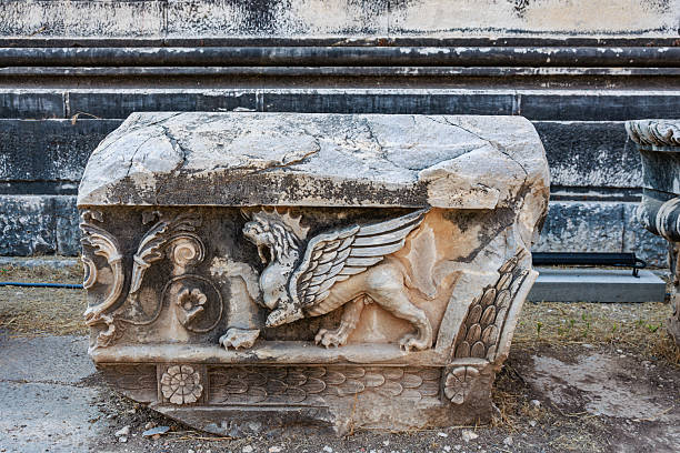 Ancient stone relief with winged lion sculpture at historical site.