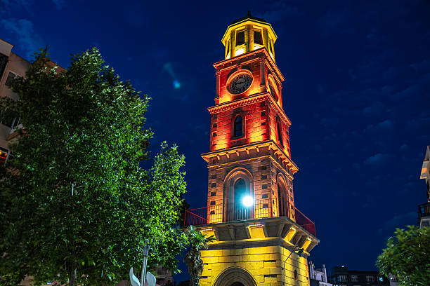Illuminated historic clock tower at night with dramatic lighting and clear sky.