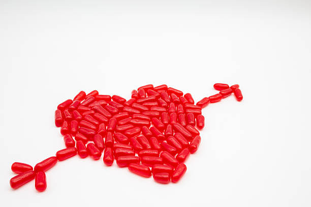 Red candy heart with cupid arrow on white background