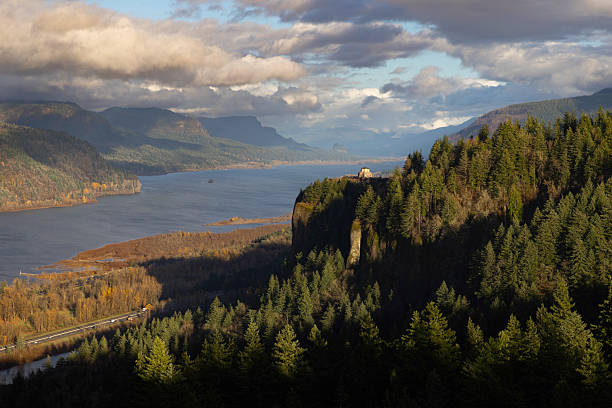 Golden hour at Columbia River Gorge with the historic Vista House at Crown Point. Lush forests and the meandering river create a serene landscape, showcasing Oregon's natural beauty. Ideal for travel and nature themes.